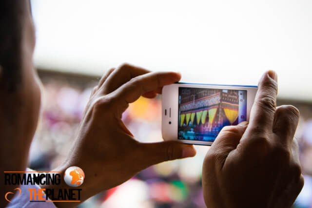 A person taking a picture of festival on his phone