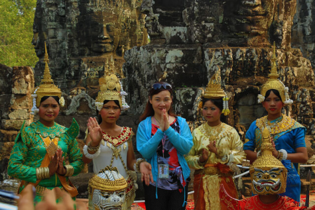 A woman posing with the Apsara in Bayon temple
